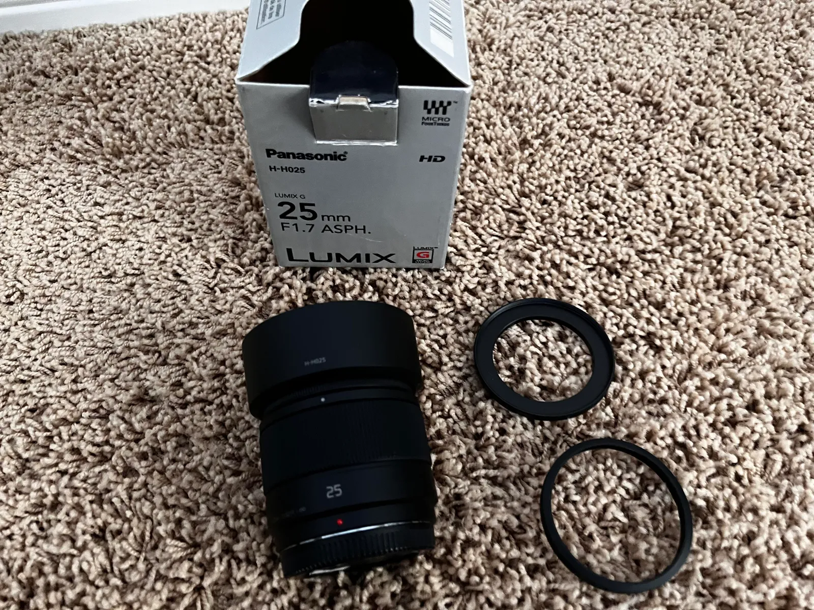 Panasonic 25mm f1.7 g lens with adapters, hood, and caps